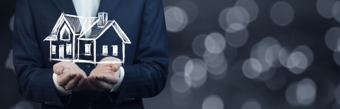 Real estate agent holding a house in his hands